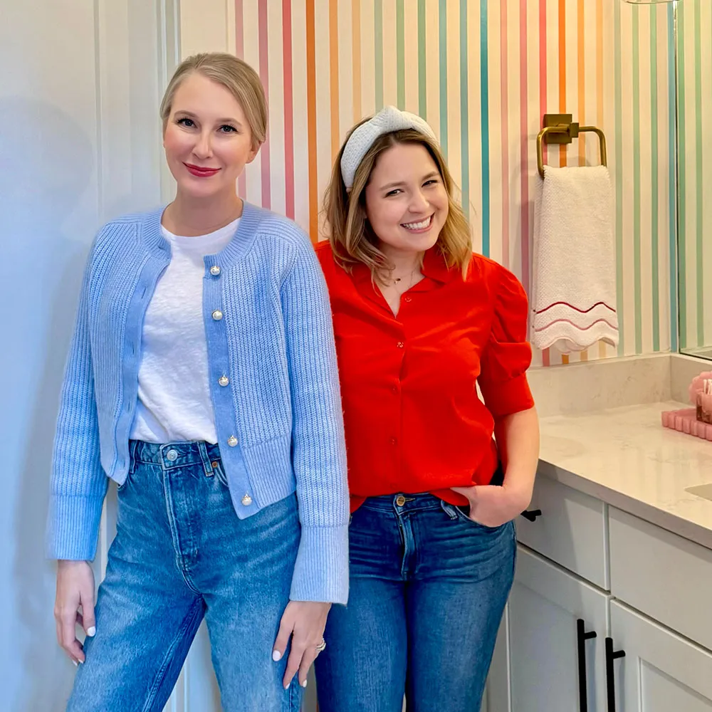 Clea & Johanna from the Netflix show Get Organized with The Home Edit in a rainbow striped bathroom.