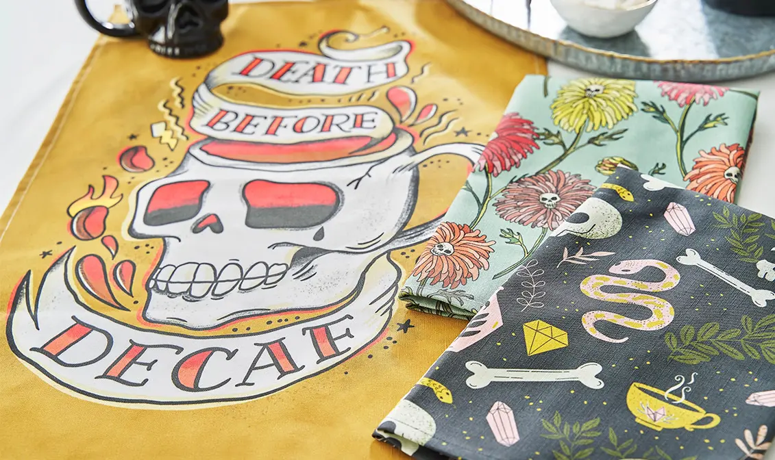 Skull and coffee themes tea towels on counter.
