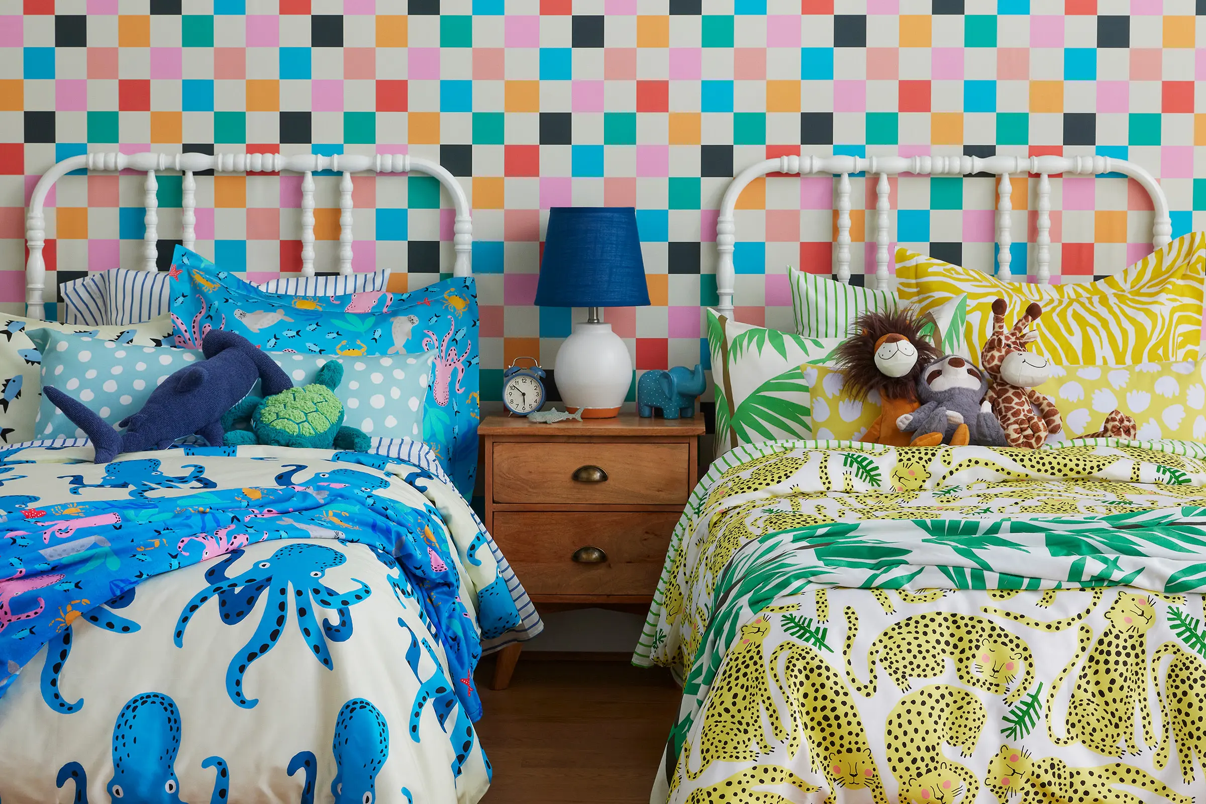 Two kids twin beds one with blue octopus bedding and one with yellow tiger bedding