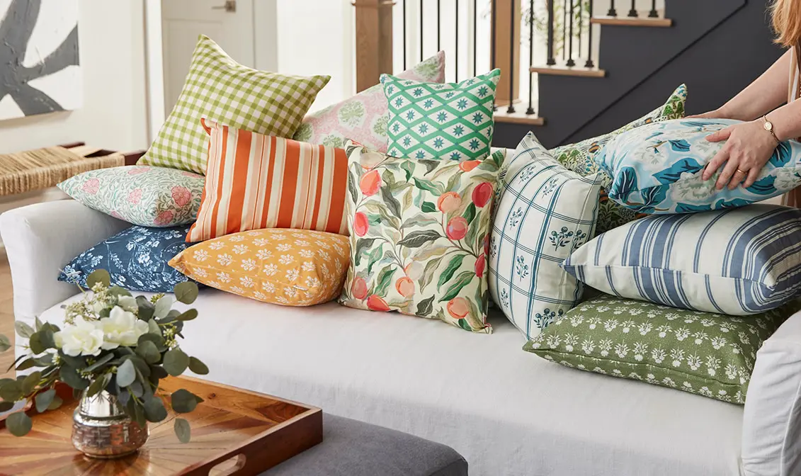 Couch covered in traditional cottage patterned throw pillows.